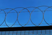 A flat barrier on the fence made of an anti-climb mesh